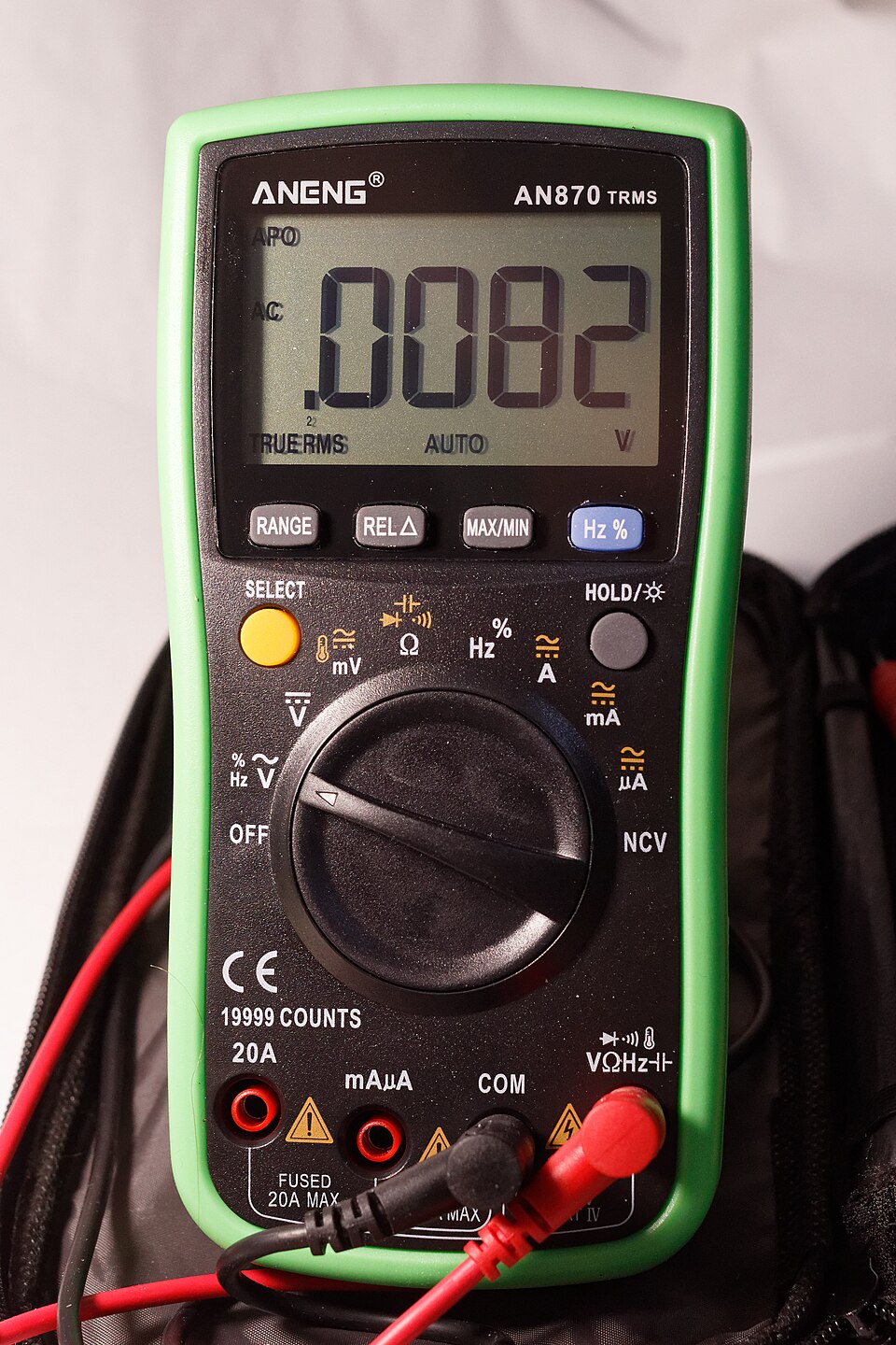 A digital multimeter with a rotary dial and red and black test leads